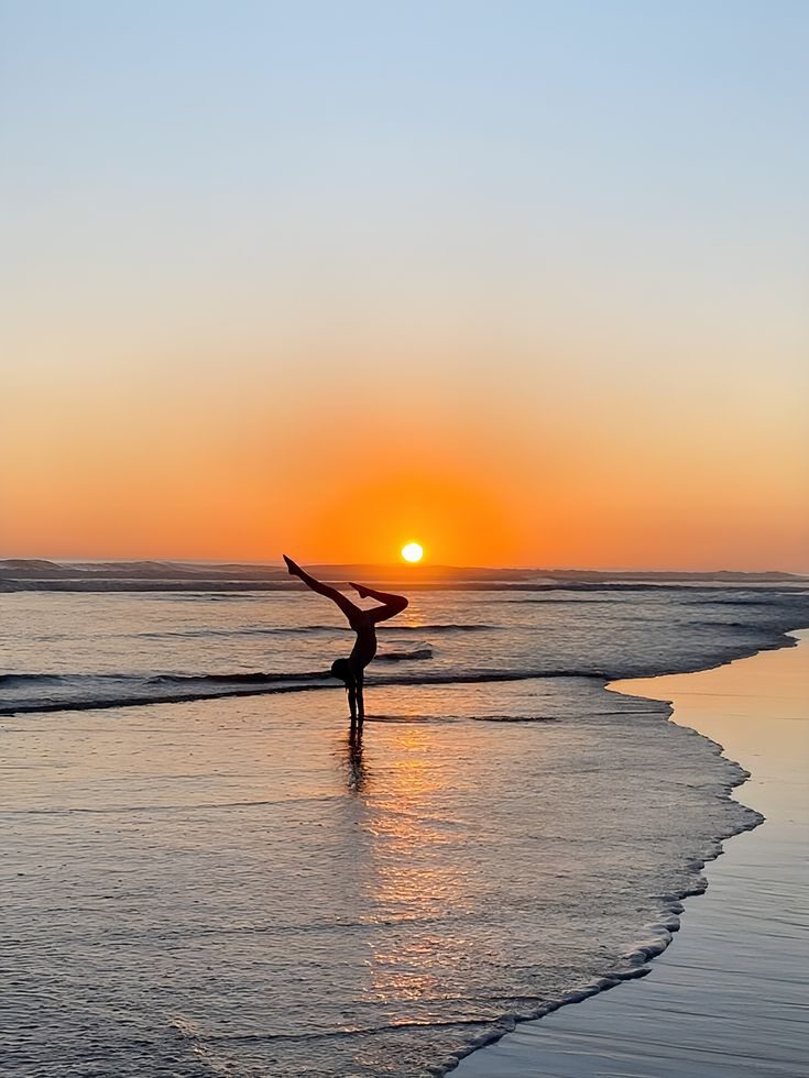 Aleksandra in a handstand on the beach at sunset